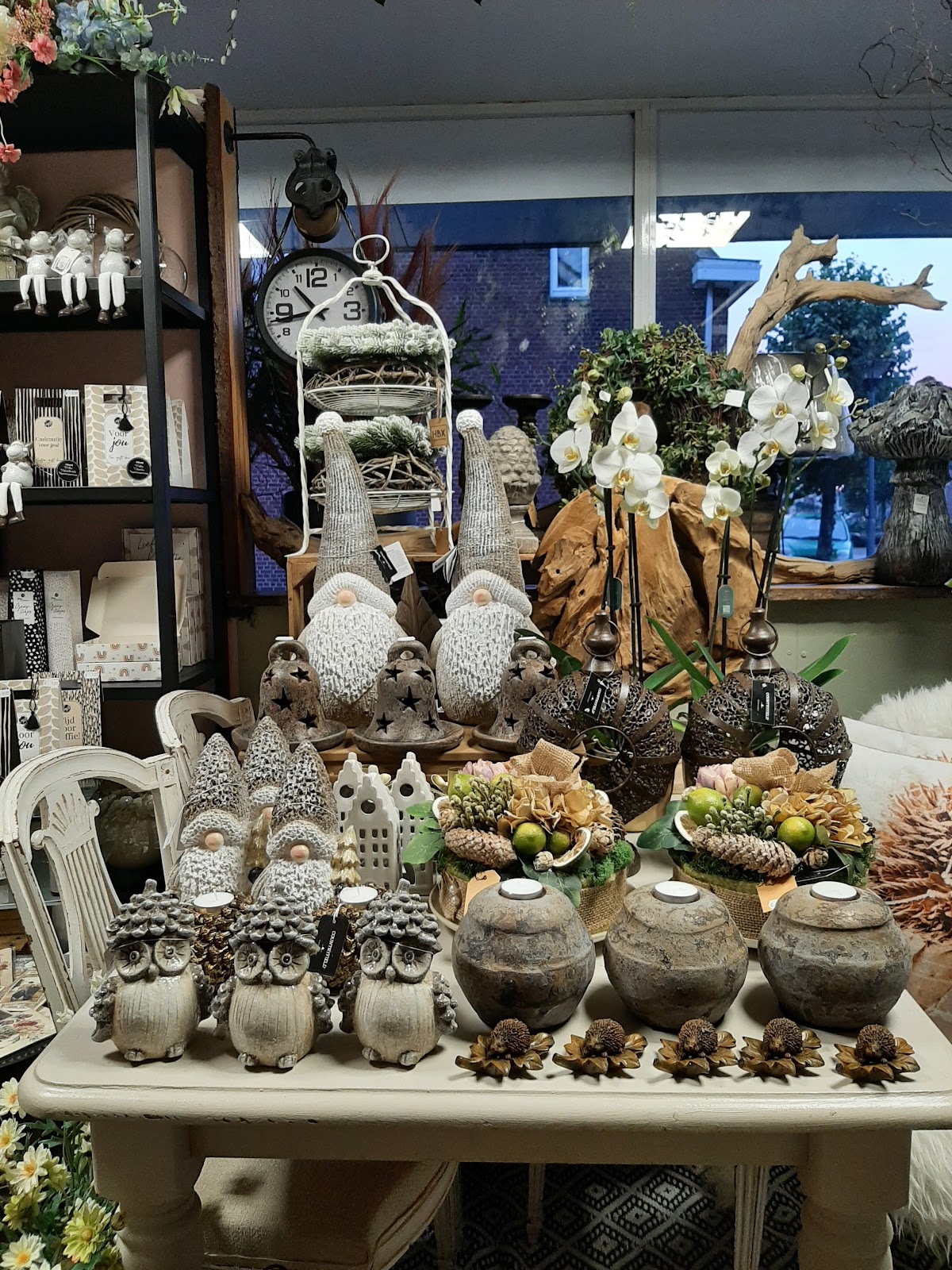 Displaytafel in de winkel: arrangementen, kabouters en lampjes; raam op de Dorpsstraat.